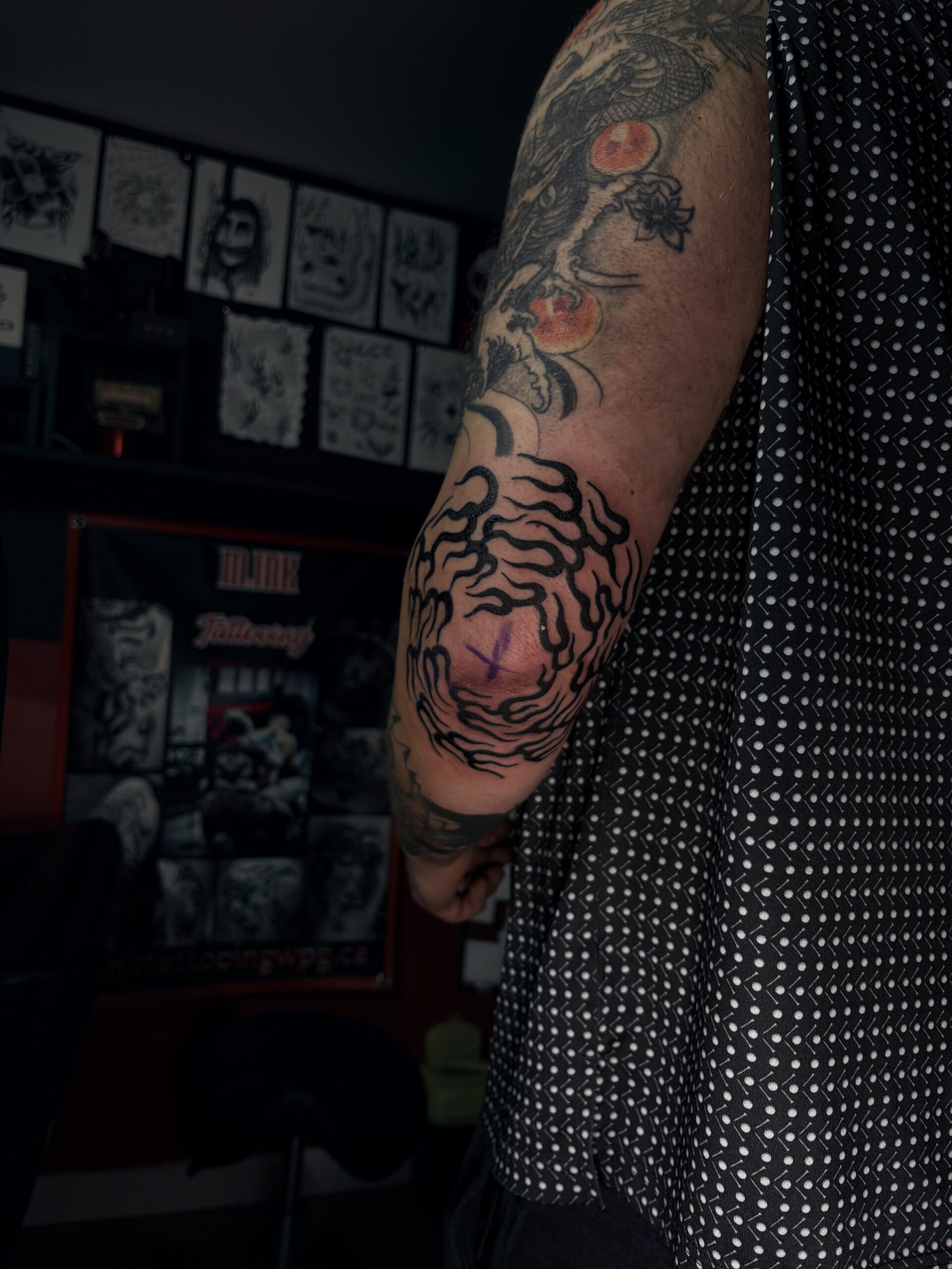 Abstract black swirl elbow tattoo inside M.INK studio